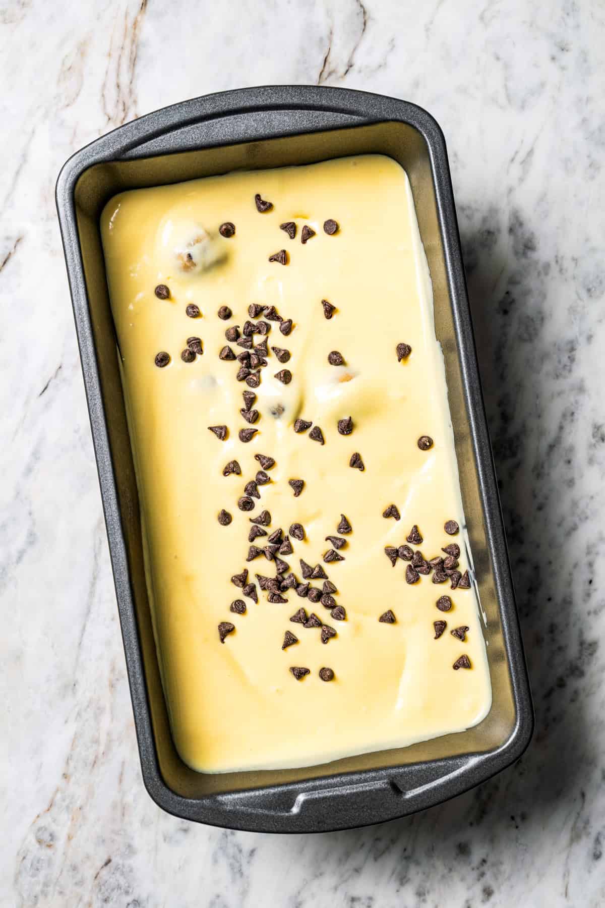 This chocolate chip cookie dough ice cream combines creamy homemade vanilla ice cream with irresistible chunks of buttery cookie dough. A pan of homemade chocolate chip cookie dough ice cream by Diethood.