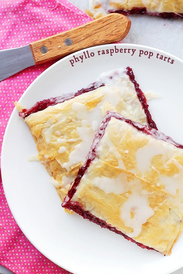 Two Phyllo Raspberry Pop Tarts with Vanilla Glaze served on a white plate.