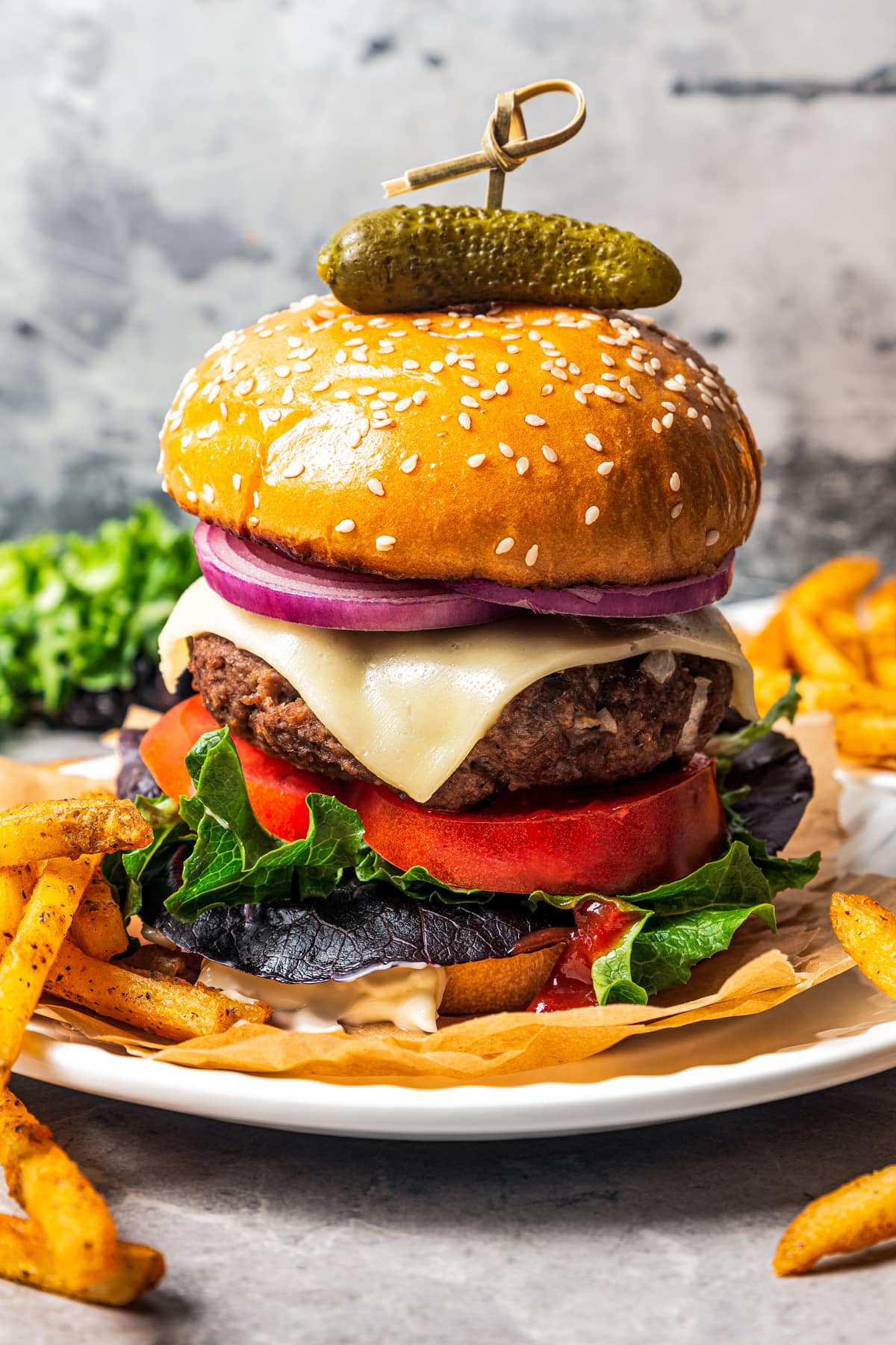 A classic American cheeseburger on a plate with french fries.