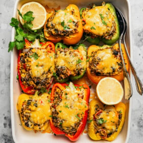 Quinoa stuffed peppers arranged in a baking dish.