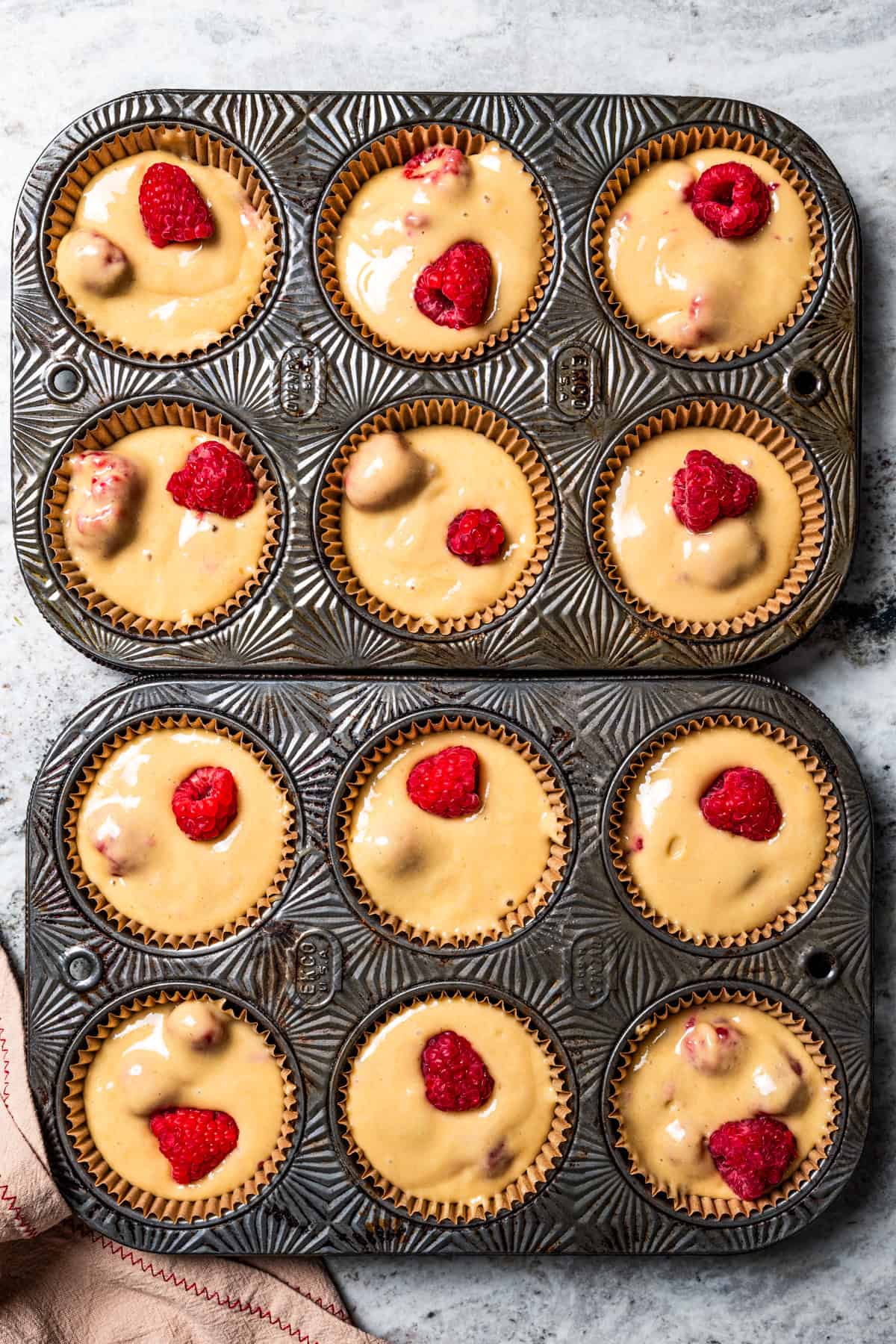 These easy raspberry muffins are fluffy and moist, made with yogurt, brown sugar, and heaps of fresh raspberries. Like summer in a muffin pan! Batter for muffins in a muffin pan.