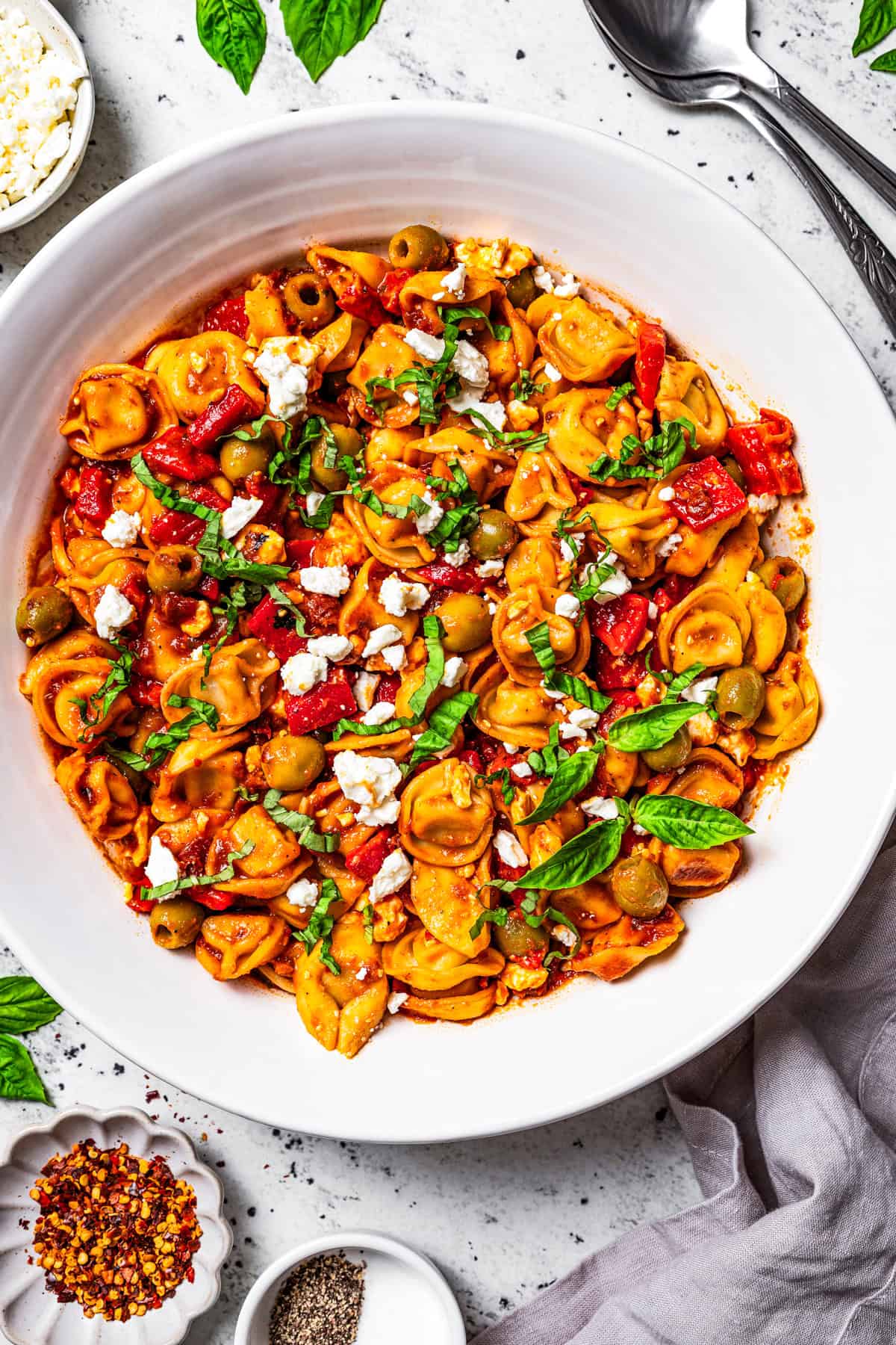 This Mediterranean tortellini pasta salad is a flavorful, easy summer side dish with cheesy tortellini, olives, red peppers, and feta cheese! Tortellini pasta salad in a large bowl.
