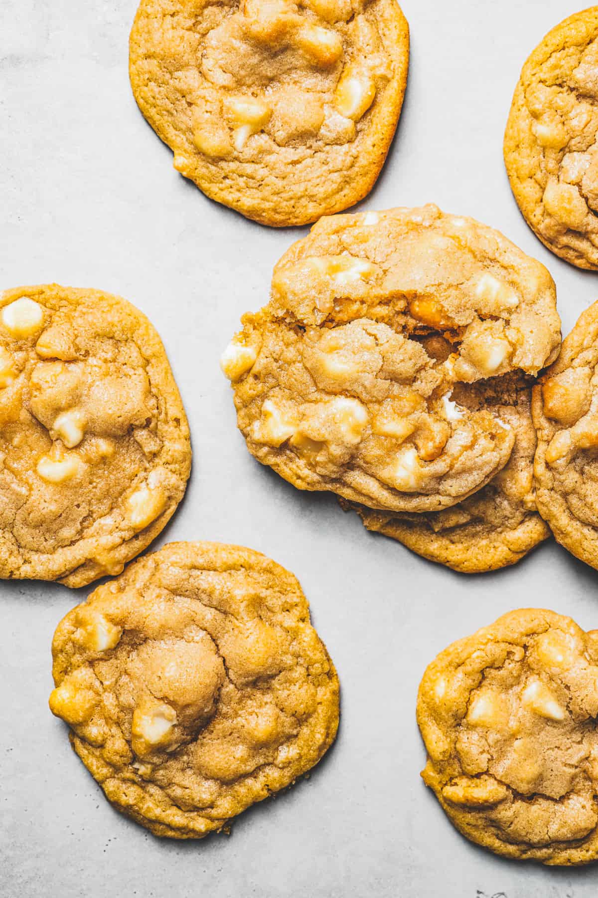 Overhead view of white chocolate chip cookies arranged on a white background.