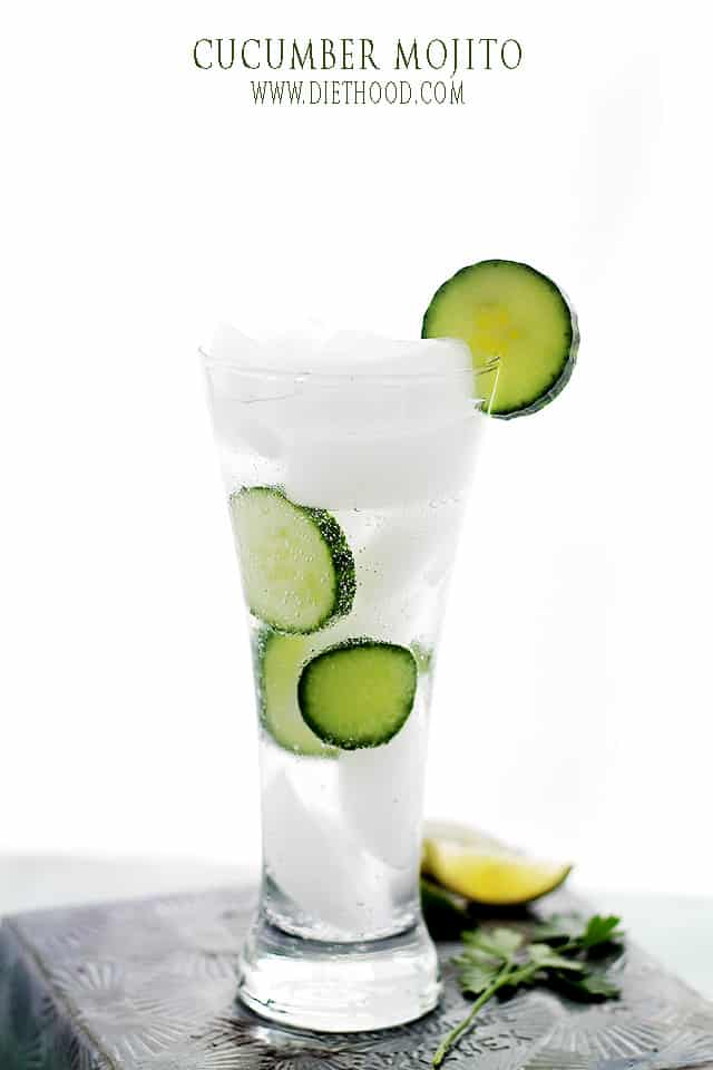 A Cucumber Mojito in a tall glass with ice and cucumbers 