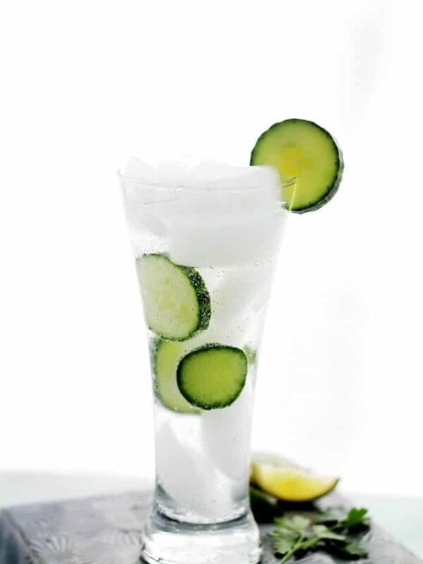 Cucumber Mojito served in a drinking glass with ice and cucumber slices.