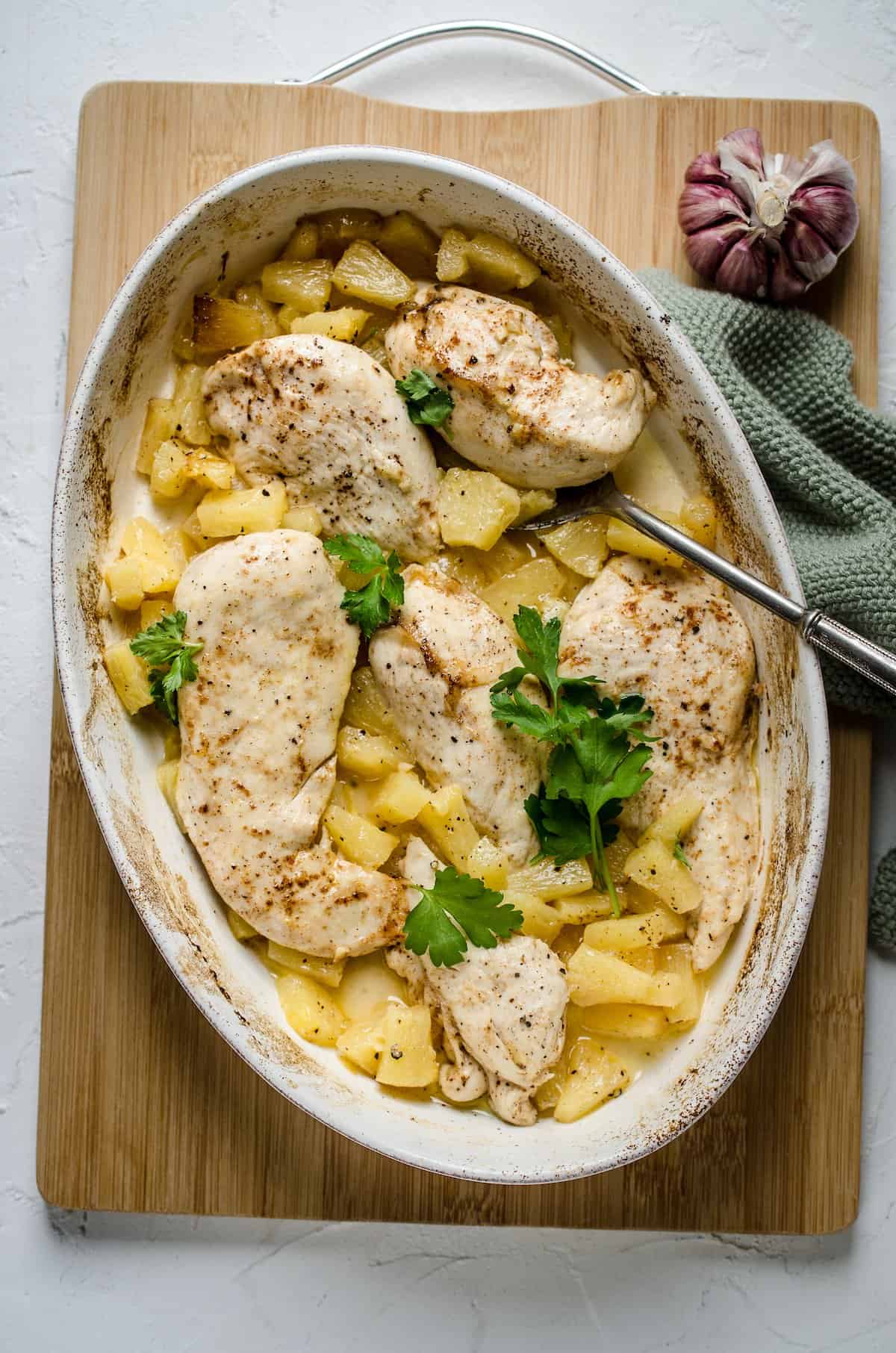 Hawaiian chicken breasts arranged in a baking dish with a pineapple topping.