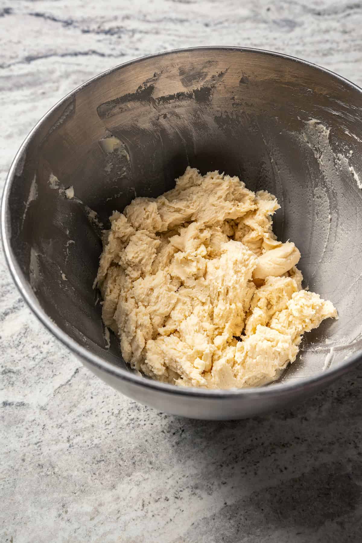 Kolacky pastry dough in a metal mixing bowl.