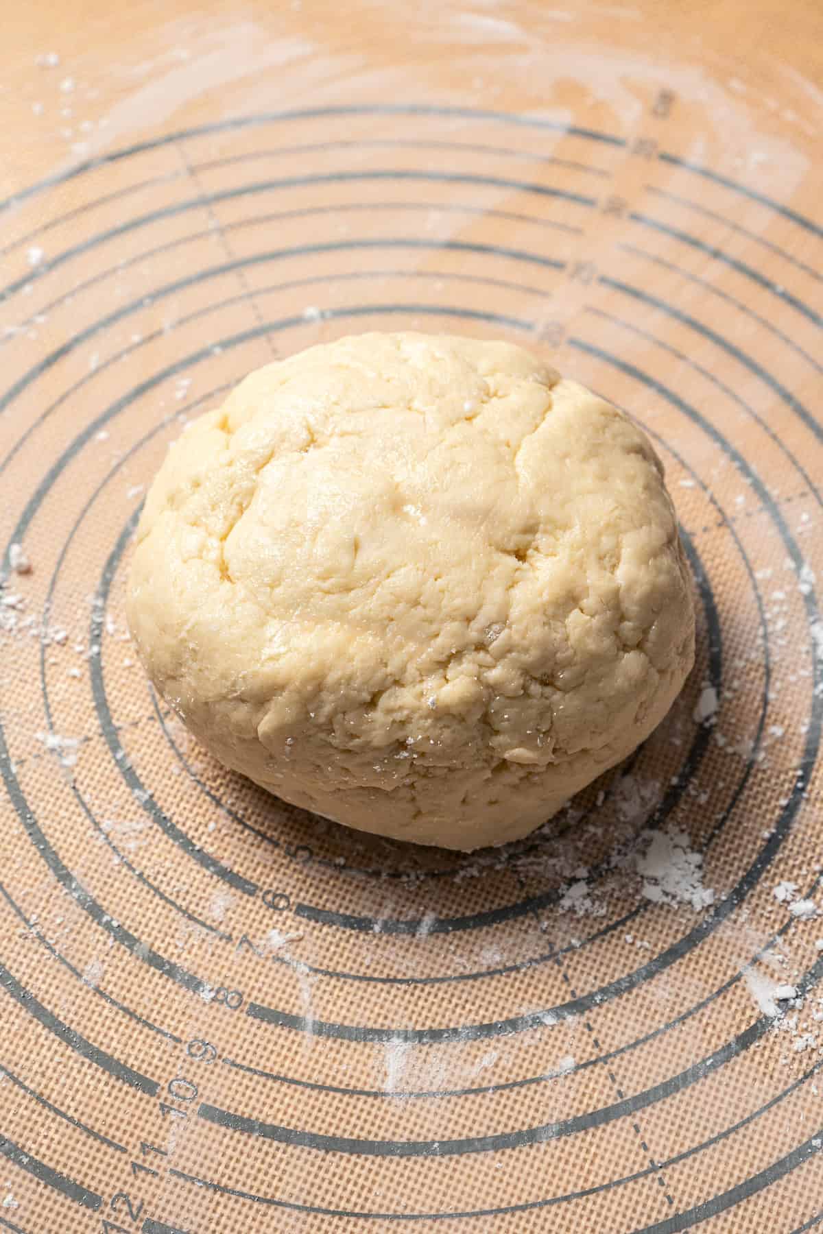 A ball of kolacky dough on a floured surface.