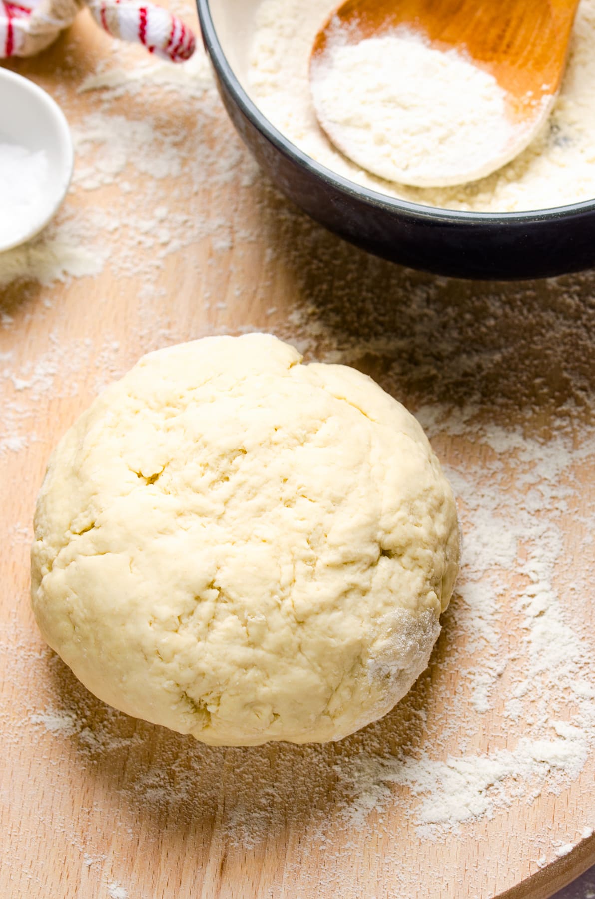 A ball of homemade dough on a wooden surface.