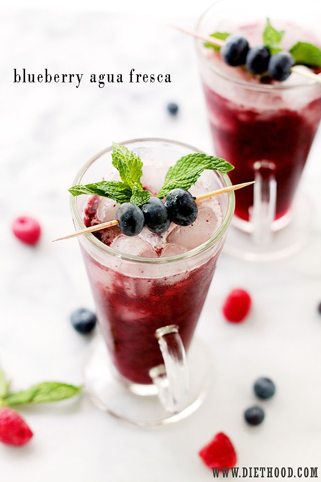 Top view of a colorful Agua Fresca drink in a glass with blueberries and mint
