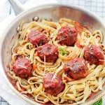 Cream cheese pork meatballs with sauce and pasta in a pan.