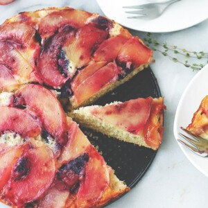 Overhead view of peach upside down cake cut into slices.