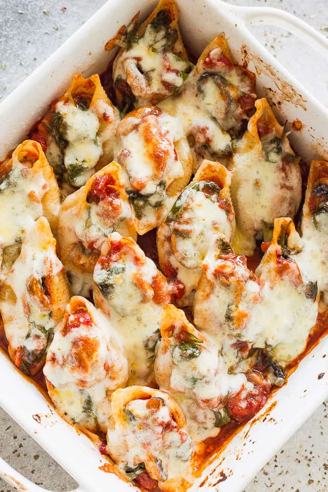 These delicious, cheesy spinach stuffed shells are an easy vegetarian dinner that's freezer-friendly and perfect for busy weeknights. Baked cheesy stuffed shells with spinach in a baking dish.