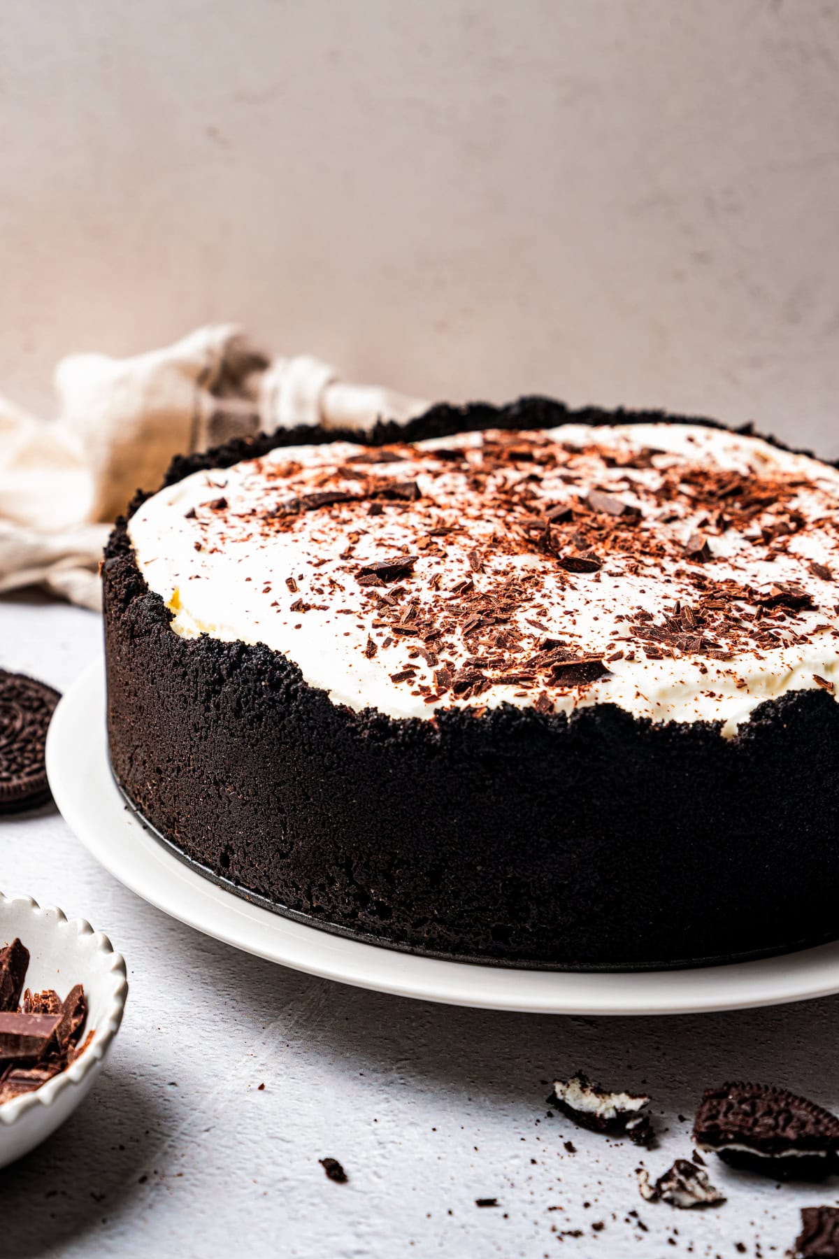 A whole Mississippi mud pie garnished with chocolate shavings inside an Oreo crust on a white plate.