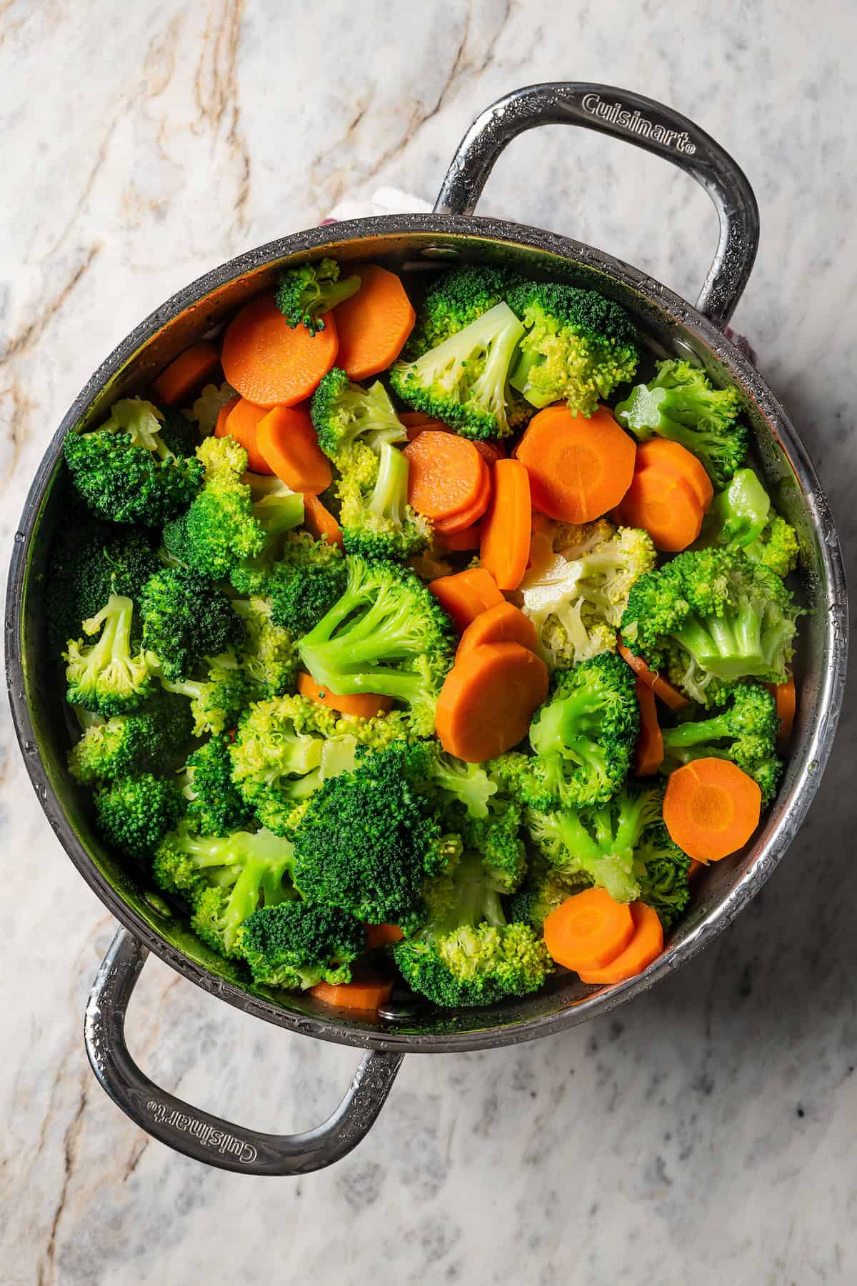 Parboiled broccoli and carrots in a pot.