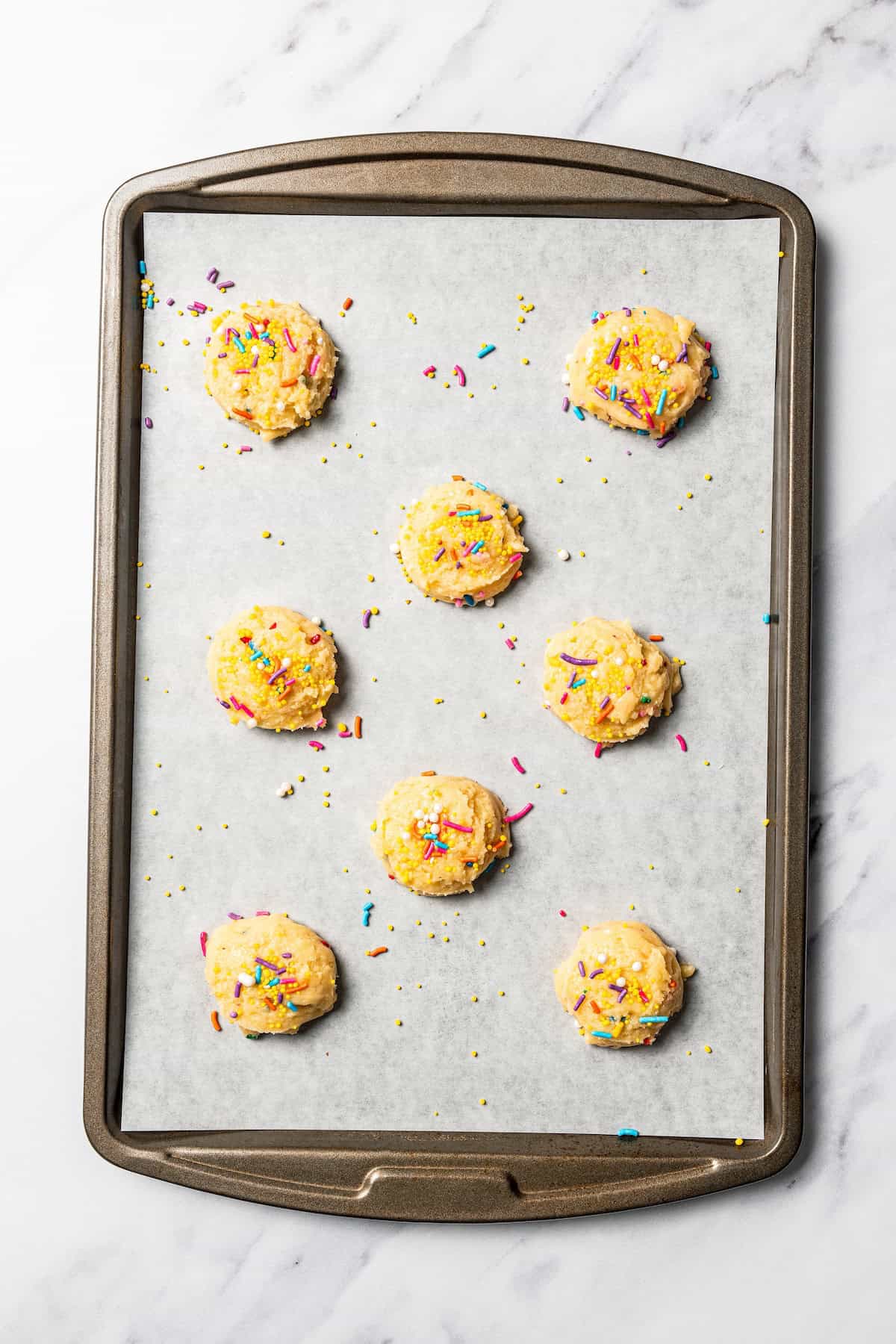 Funfetti cookie dough portioned onto a baking sheet.