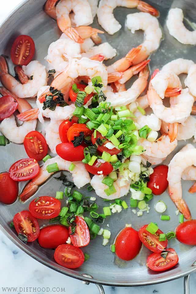 This lemon shrimp spaghetti is an easy 30-minute dinner with juicy shrimp, tomatoes, spinach, garlic, and plenty of fresh lemon flavor. Shrimp and tomatoes cooking in a skillet.