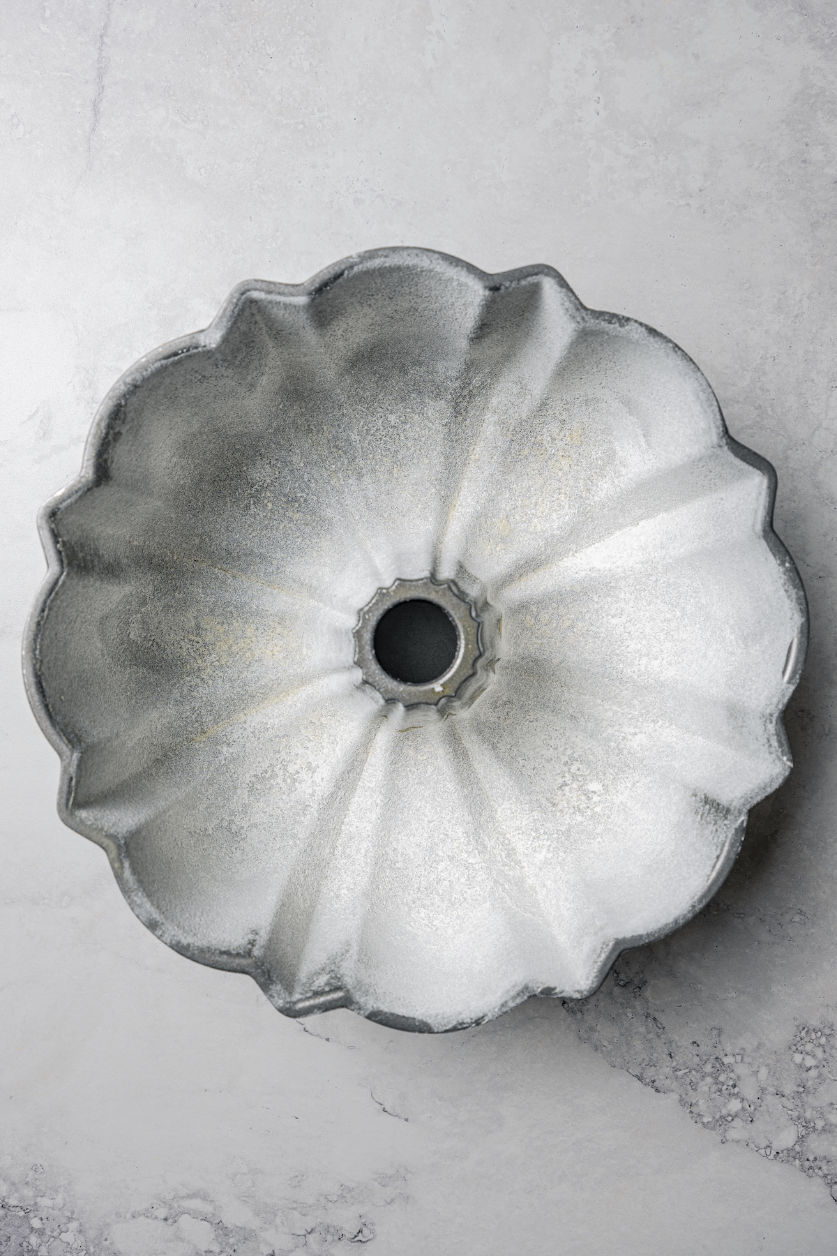 Overhead view of a greased and floured bundt pan.