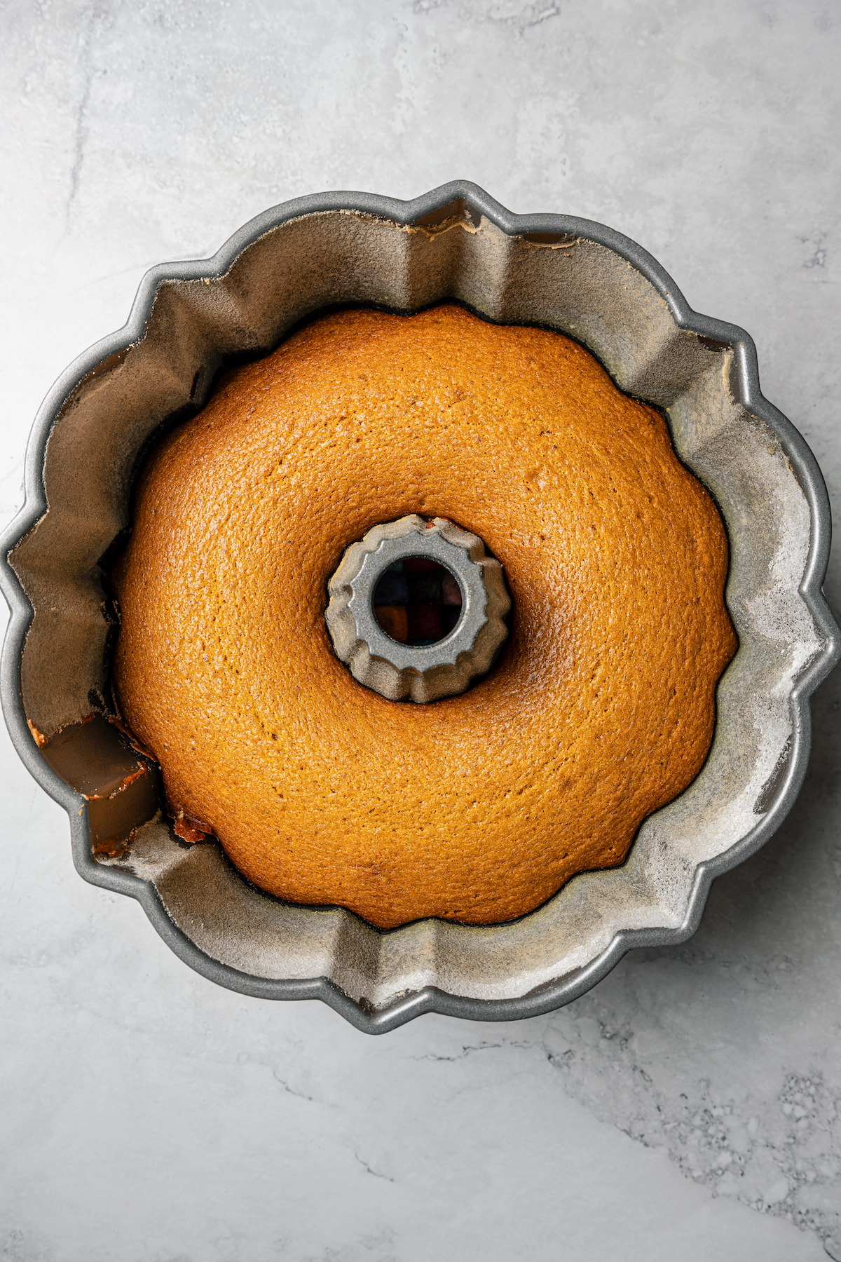 Baked pumpkin spice bundt cake in a bundt pan.