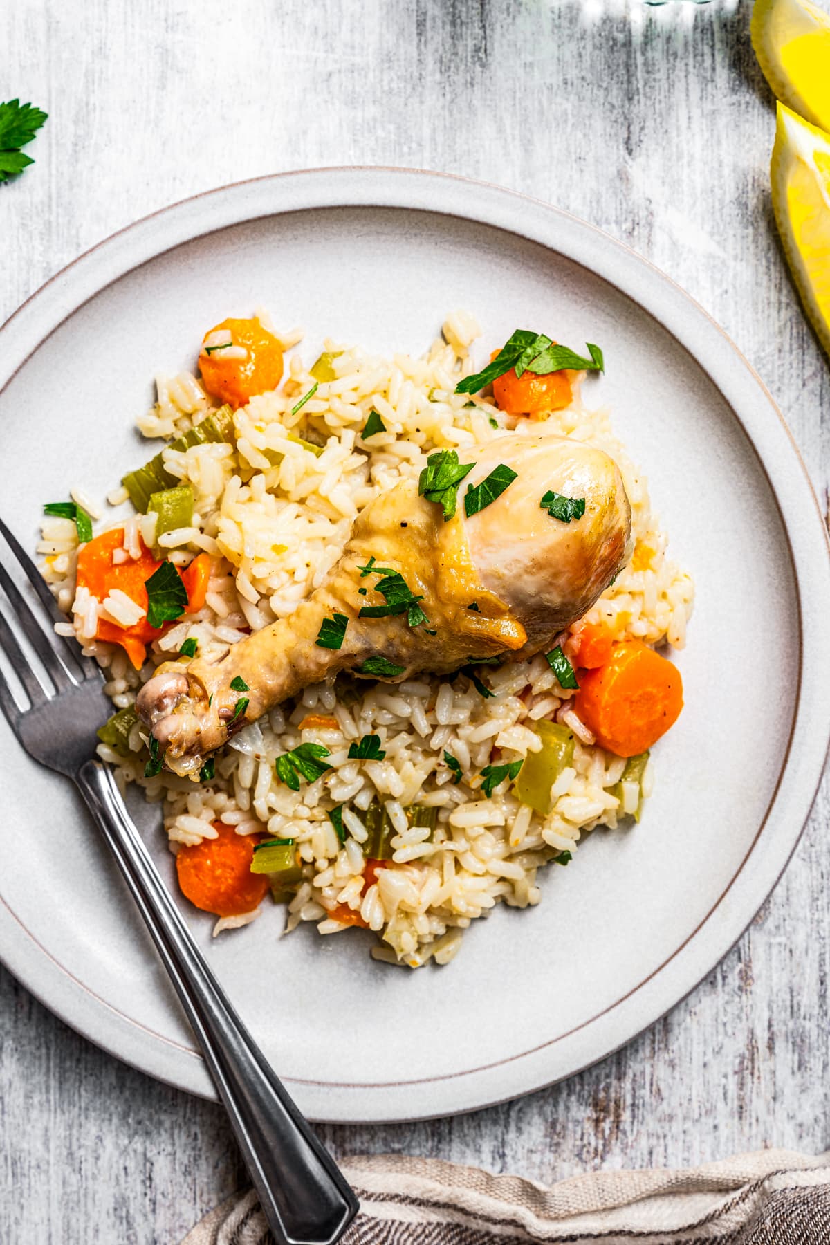 Overhead view of a serving of chicken and rice on a plate next to a fork.