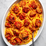 Overhead view of a large platter of spaghetti and pork meatballs.