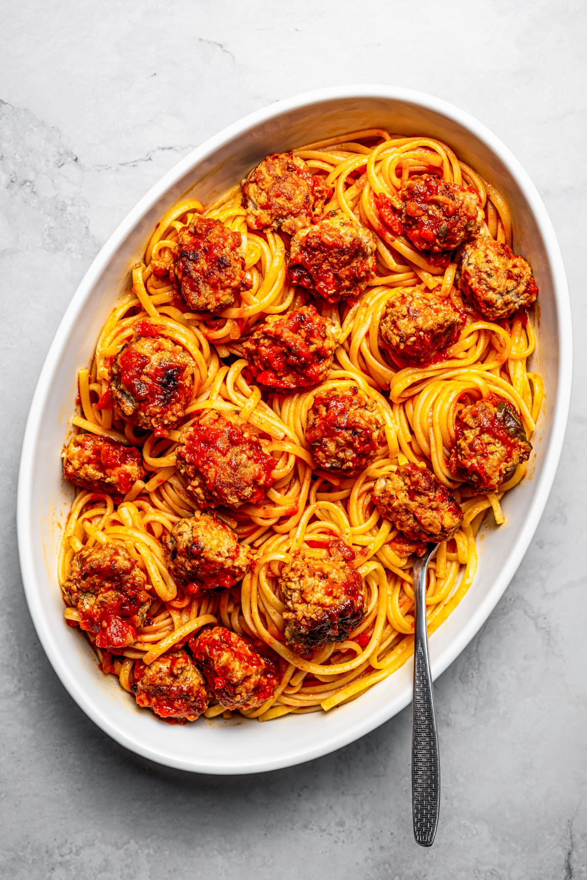 Overhead view of a large platter of spaghetti and pork meatballs.