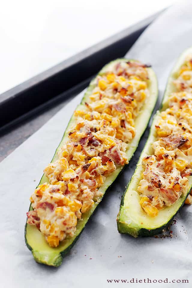 Two zucchini boats stuffed with bacon, corn, and cheese.