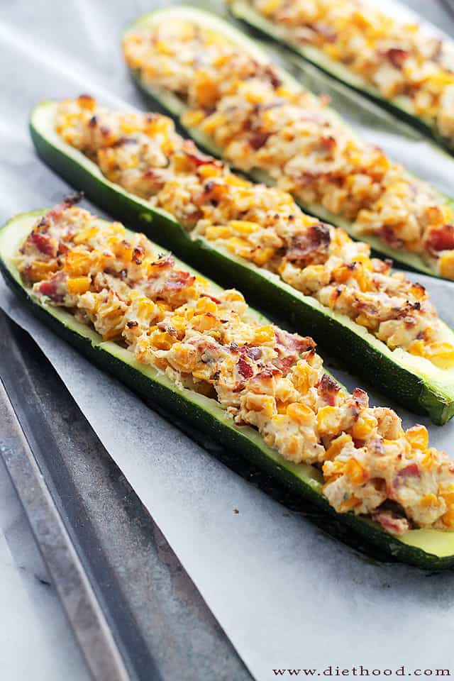 Image of two zucchini boats stuffed with corn, cheese, and bacon.