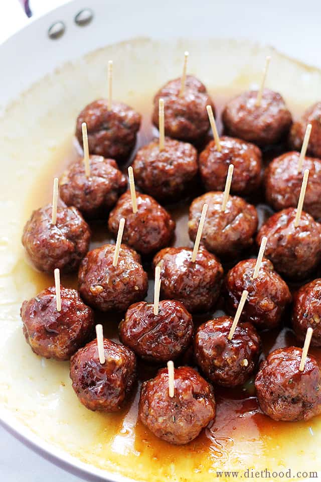 A pan full of glazed Turkey Meatballs with toothpicks in them