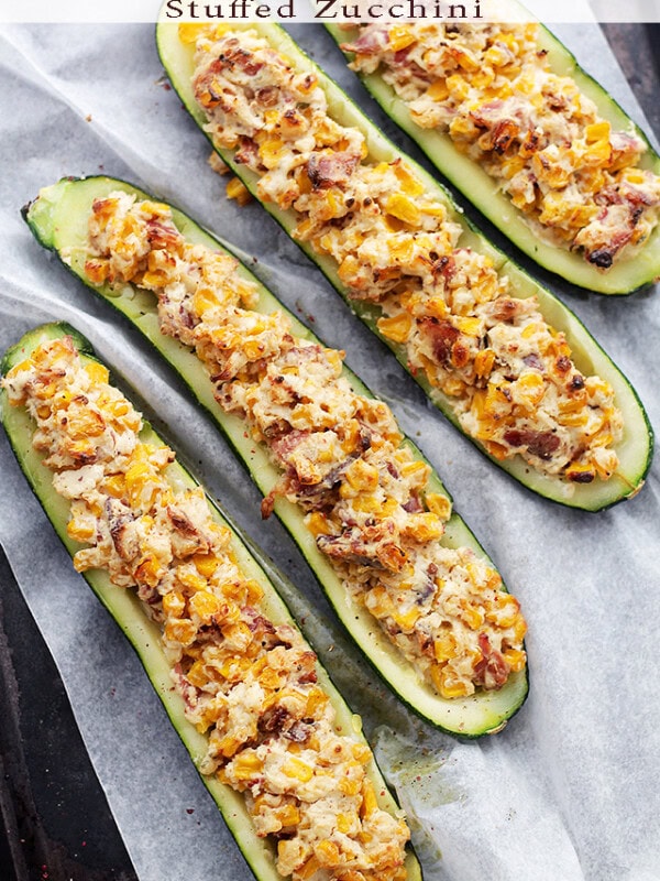 Overhead image of four zucchini boats stuffed with cheese, corn, and bacon.