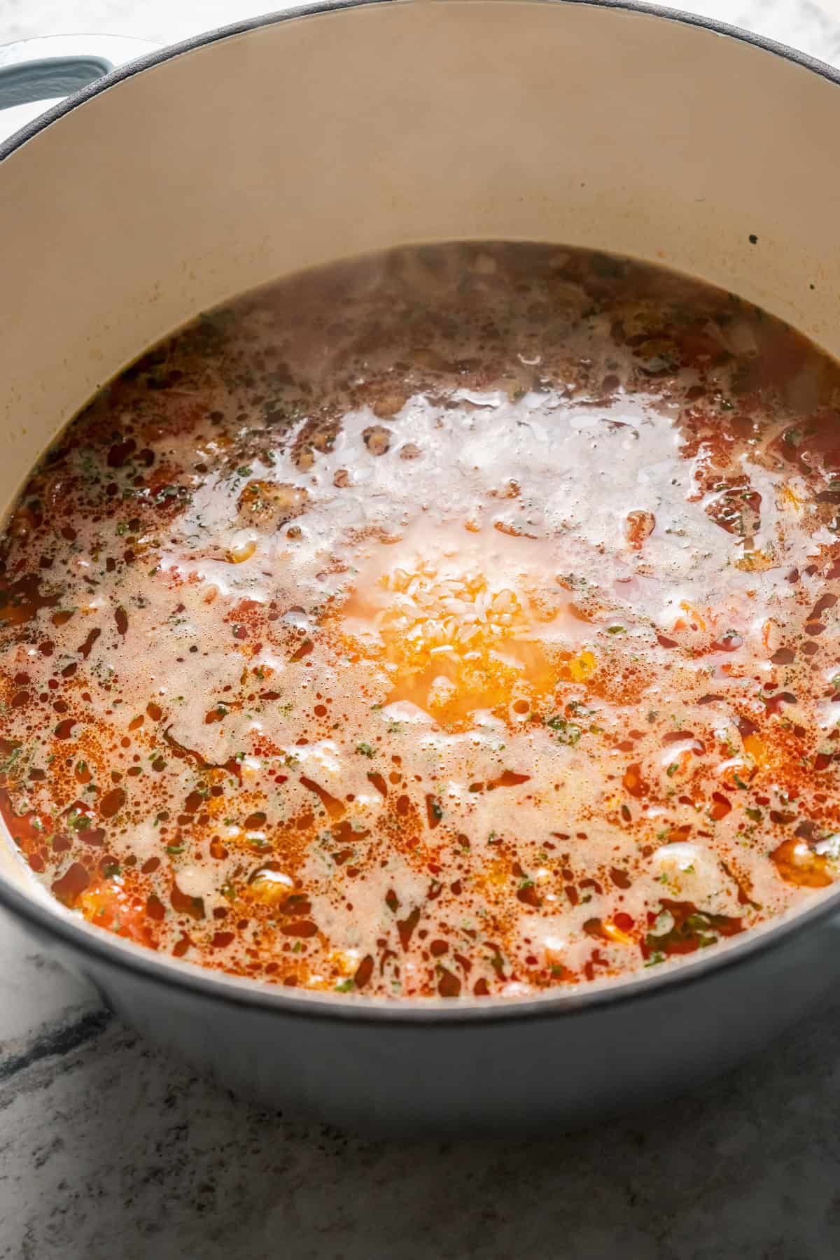 Chorizo soup simmering in a large pot.