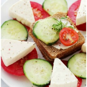 Tea Sandwiches - Flavorful whole-grain slice of bread topped with cheese wedges, cucumber slices and tomatoes.