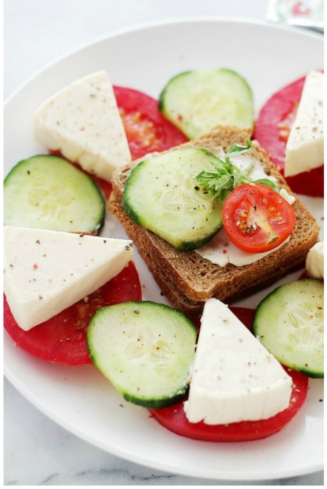 Tea Sandwiches - Flavorful whole-grain slice of bread topped with cheese wedges, cucumber slices and tomatoes.