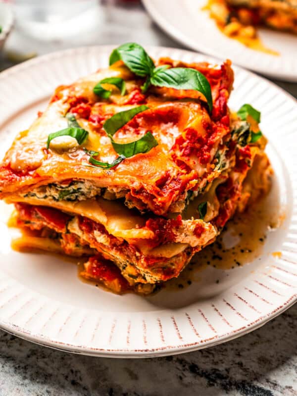 Slice of lasagna served on a white dinner plate.