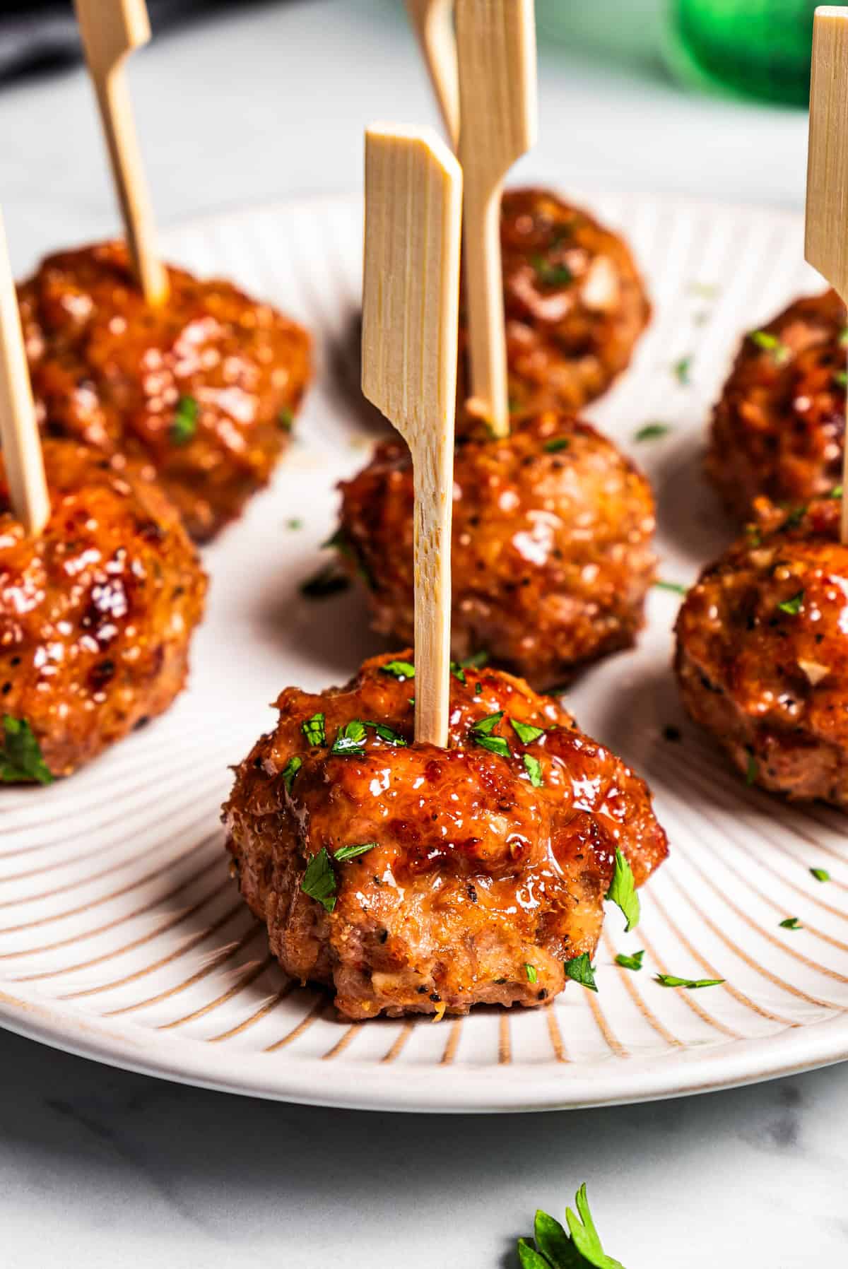 Turkey meatballs skewered with cocktail toothpicks on a white plate.