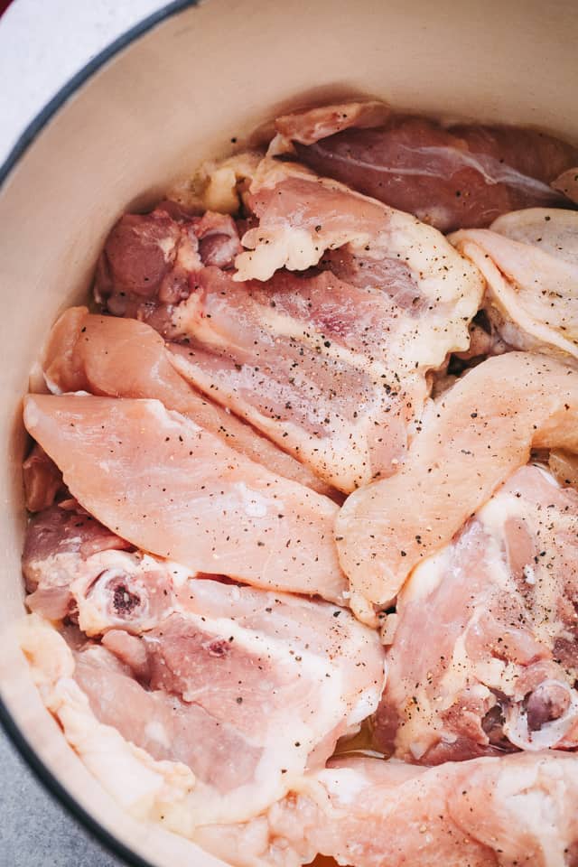 Raw chicken thighs in a pot.