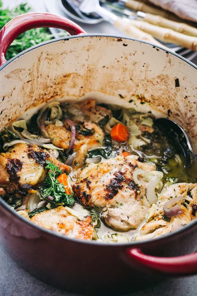 Baked Chicken with Spinach and Artichokes in a red Dutch oven.