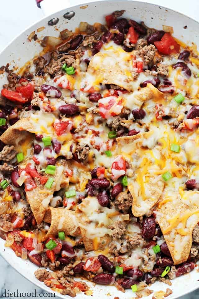 cooked ground beef, beans, tomatoes, and tortilla chips in a skillet