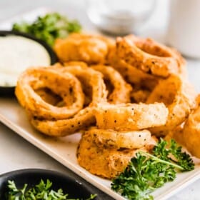 Onion rings with a bowl of dip.