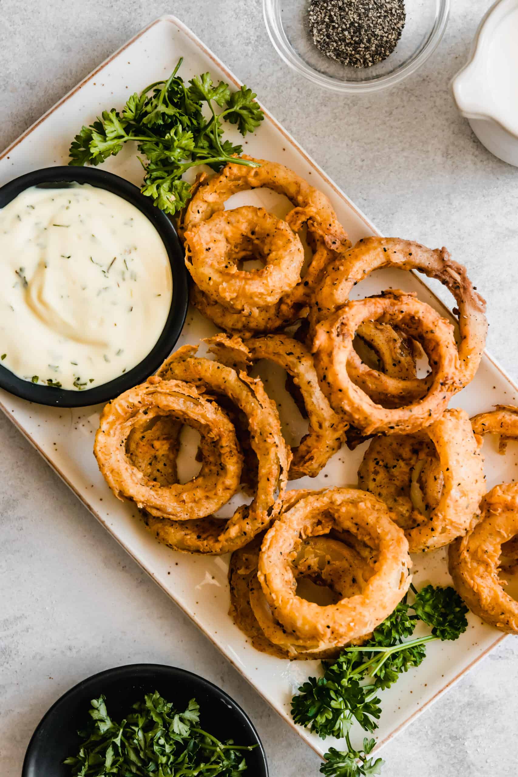 Plate of homemade onion rings with dip.