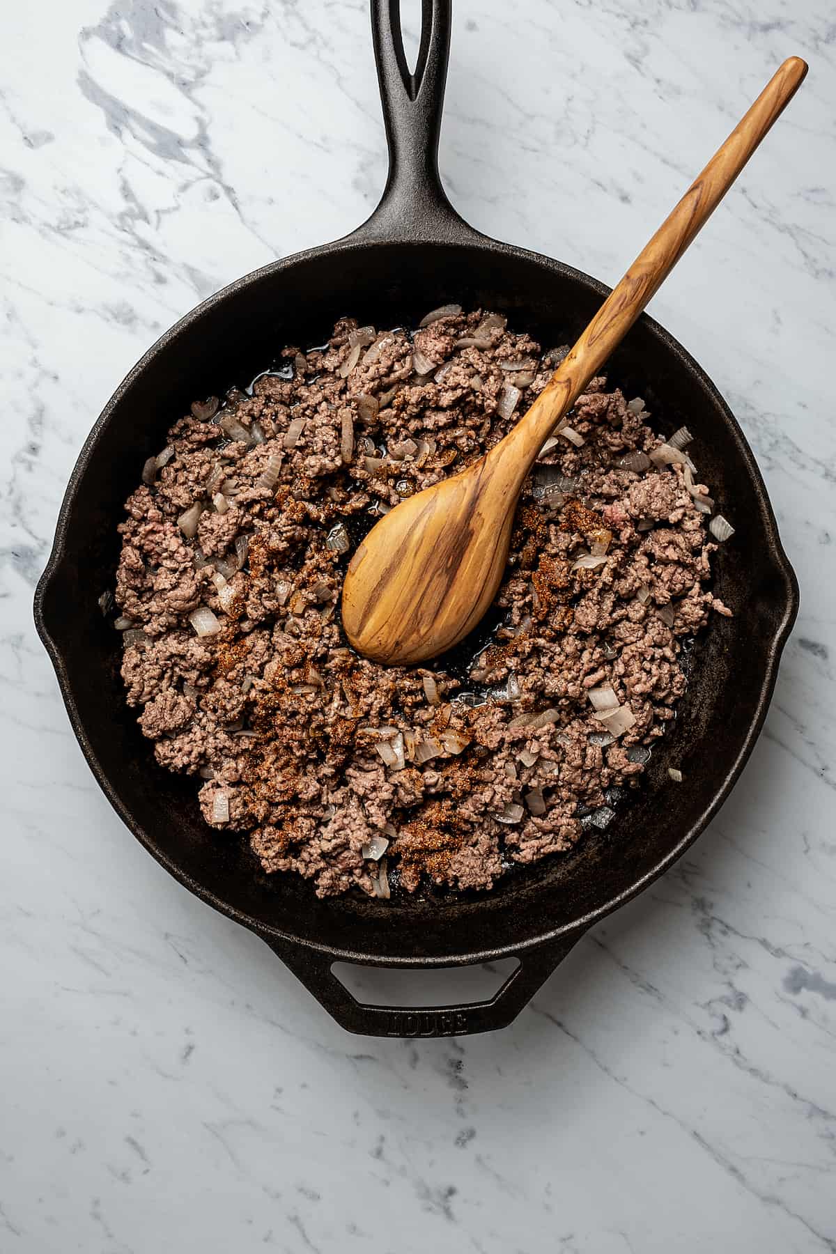 Seasoned ground beef in a cast-iron skillet.