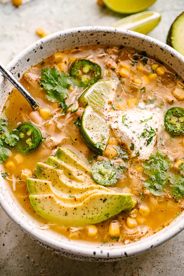 serving slow cooker white chili topped with jalapenos and avocado