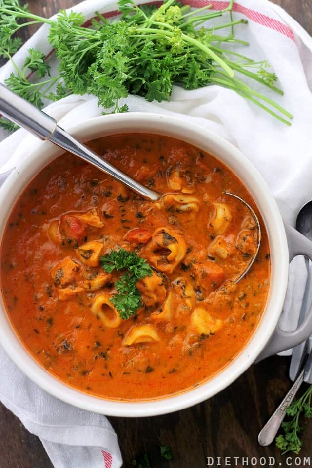 Spinach Tortellini Tomato Soup in a white bowl with a spoon