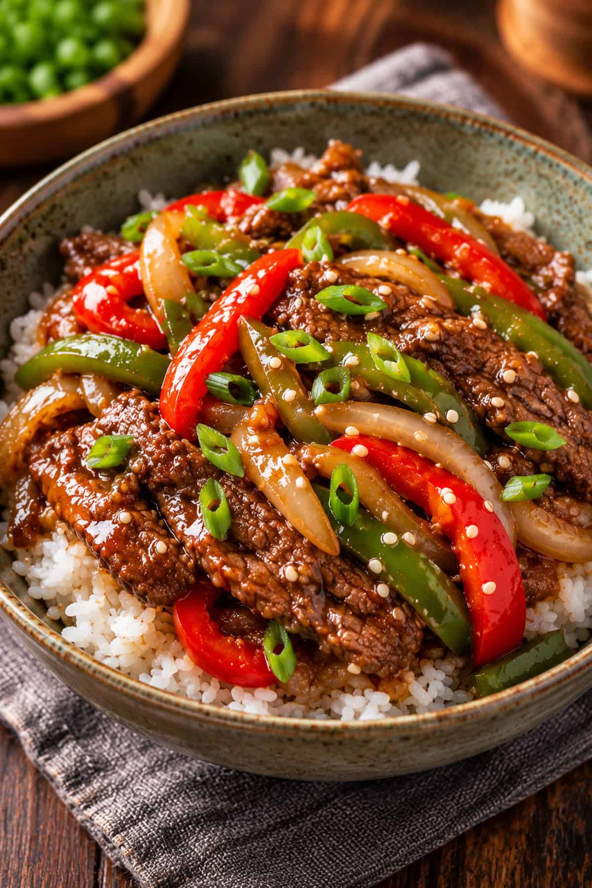 Slow cooker beef stir fry with flank steak, bell peppers, and onions served over white rice.