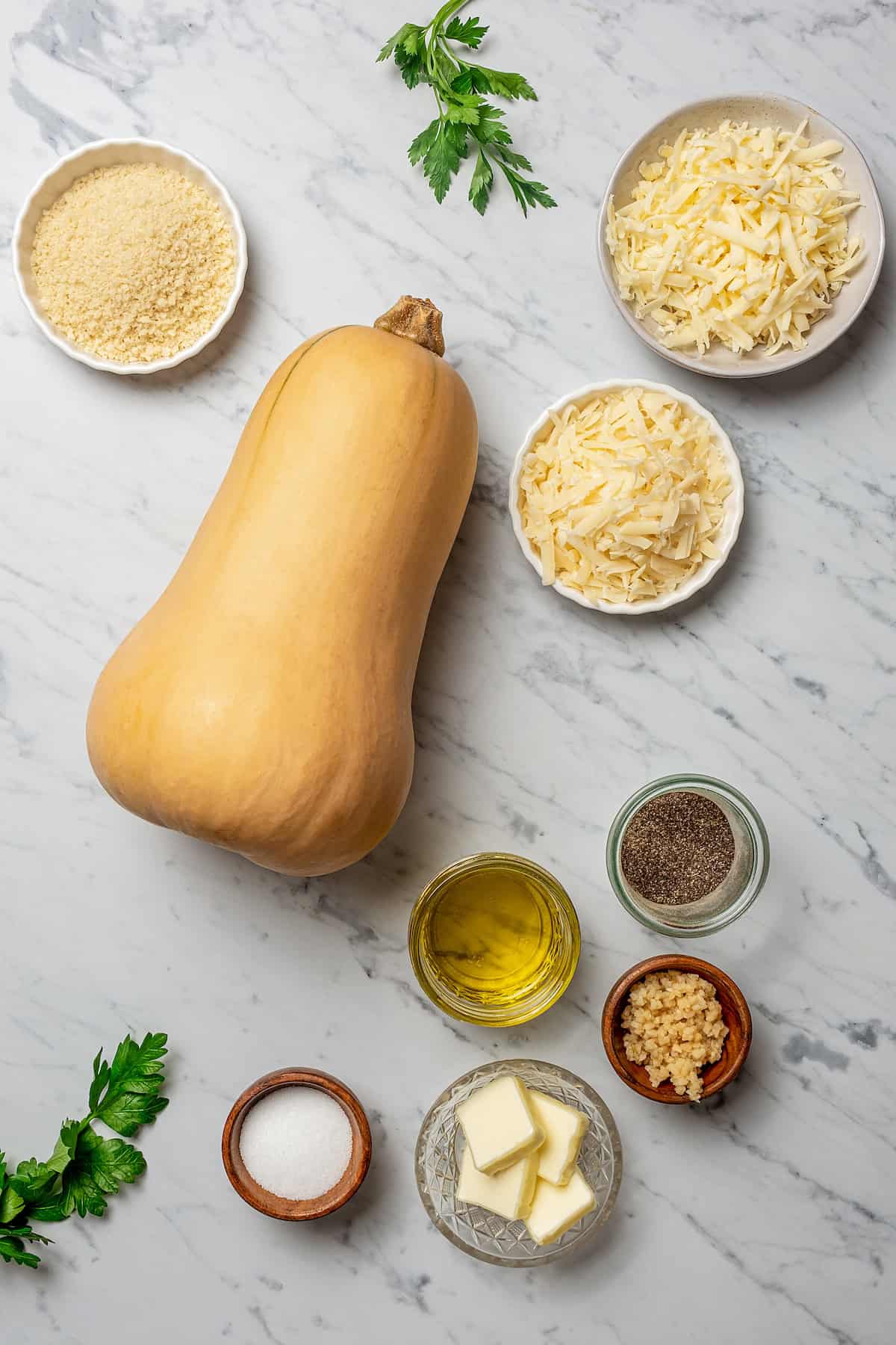 Butternut squash set in the center of ingredients that will be used for baking the squash.