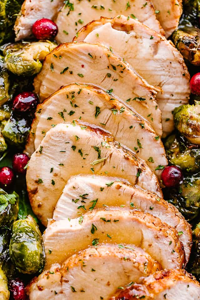 sliced turkey breast served alongside brussel sprouts.