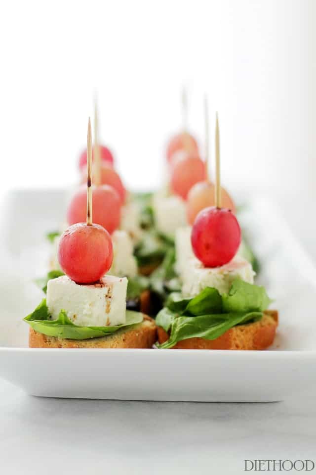 Macedonian-Style Grape Caprese Salad | www.diethood.com | This light, fresh appetizer-salad is made with red grapes, feta and spinach set atop slices of garlic toast. 