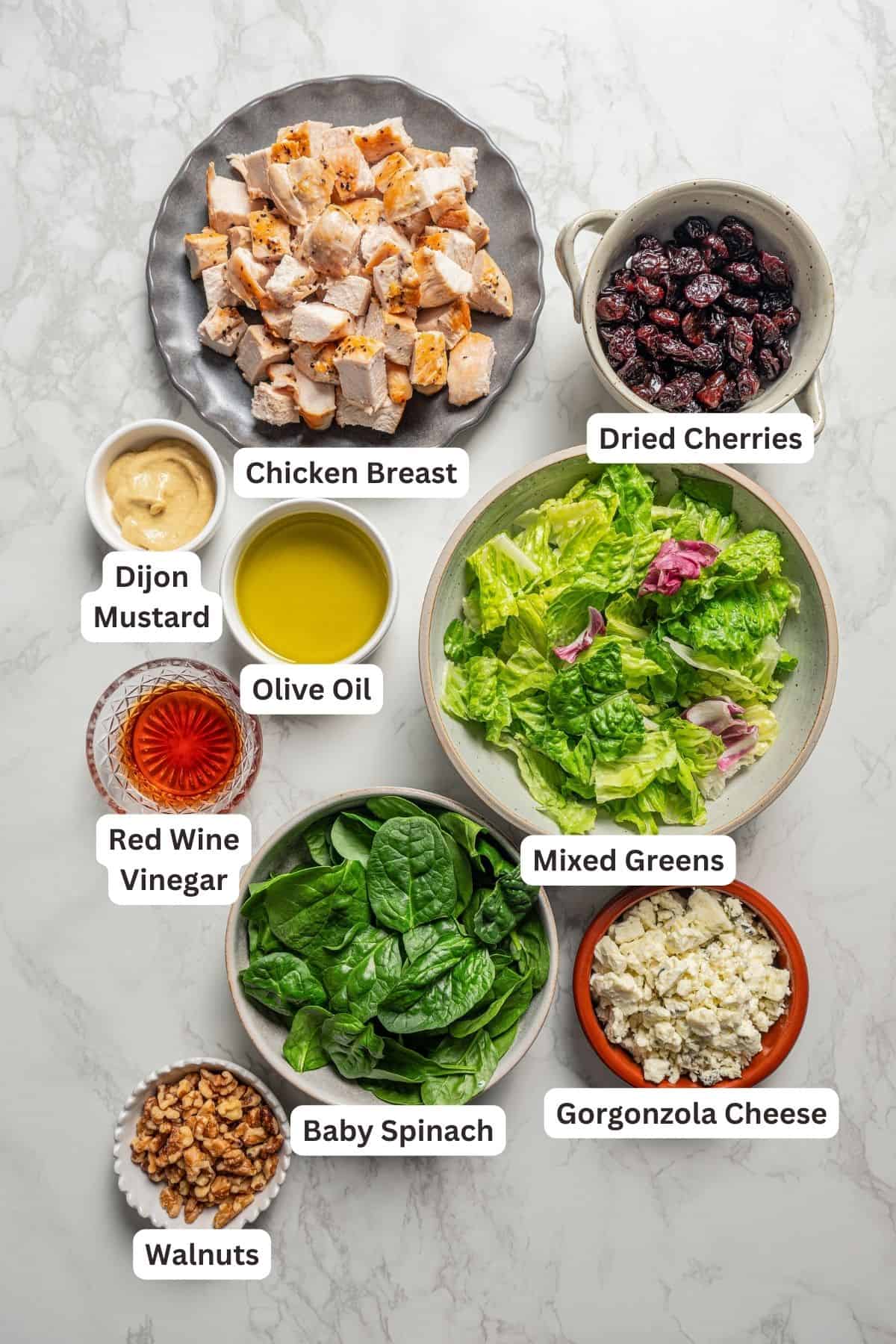 Ingredients for cherry and walnut chicken salad with text labels overlaying each ingredient.