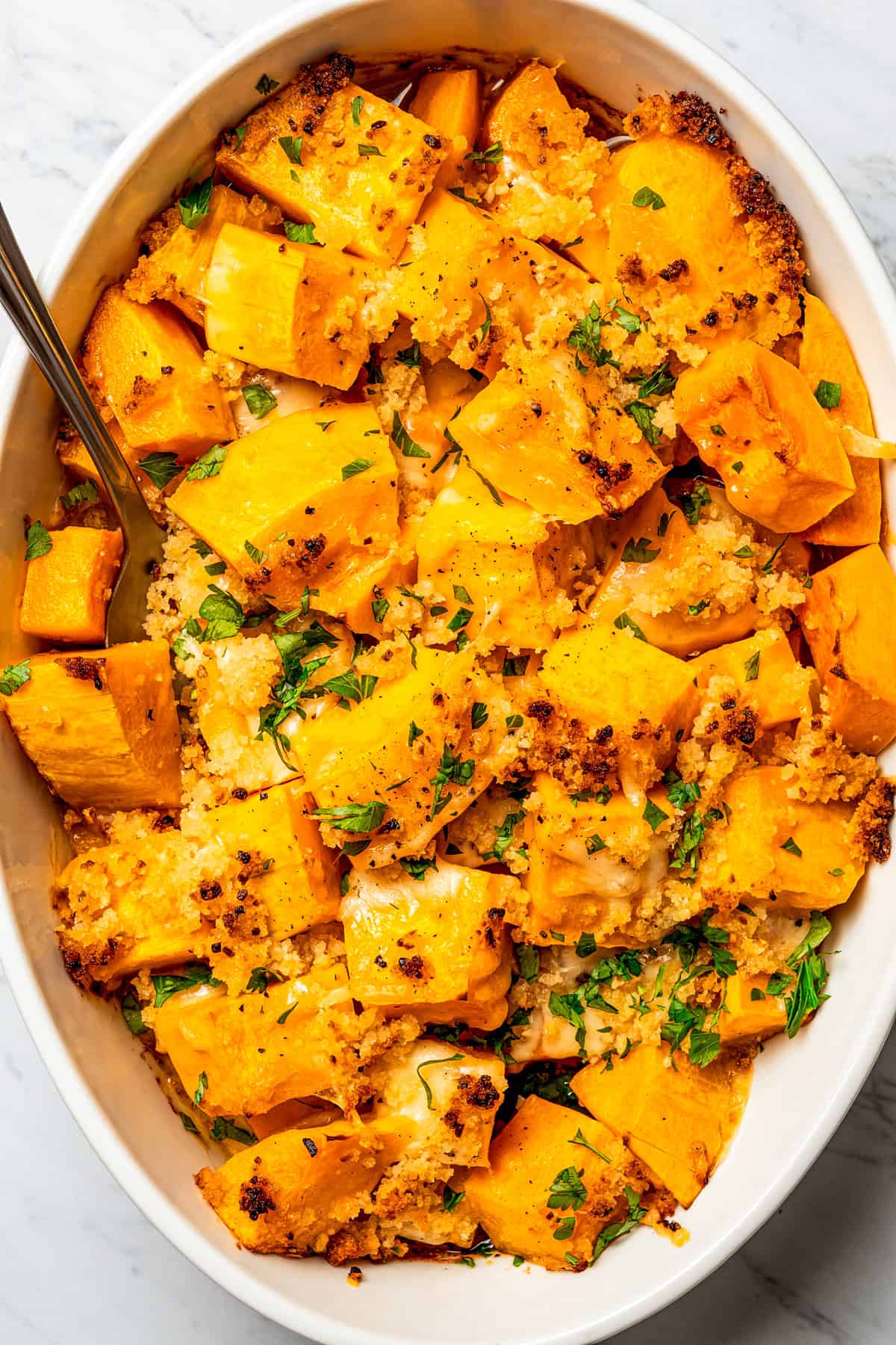 Overhead view of a baking dish with baked butternut squash.