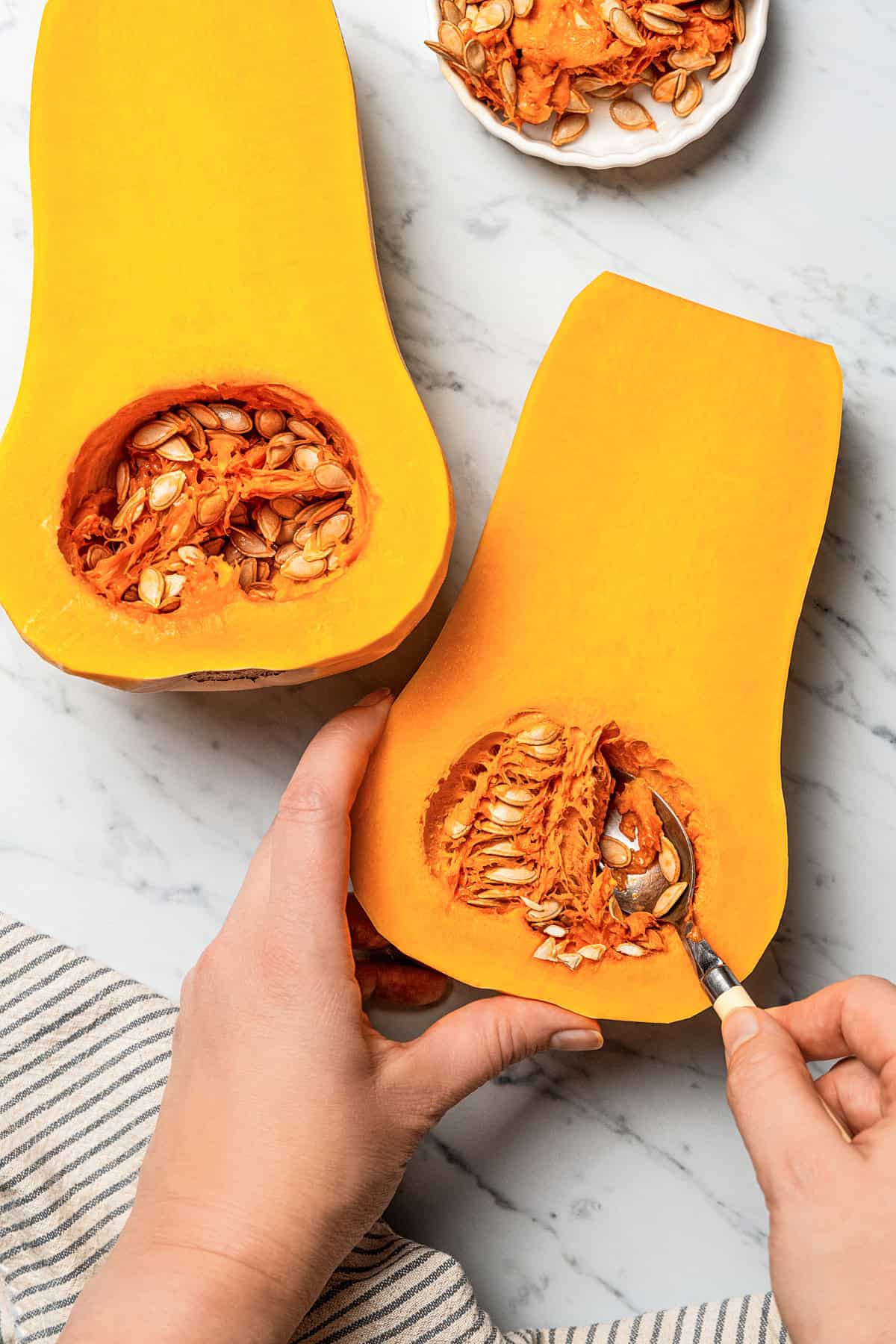 Scooping out seeds from a squash.